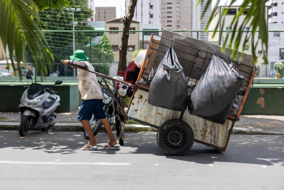 A imagem mostra um catador usando uma carroça em Fortaleza.