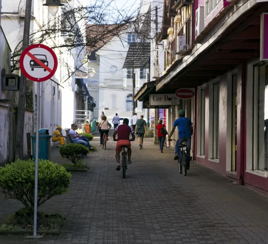 A foto mostra pessoas andando de bicicleta em Joinville.